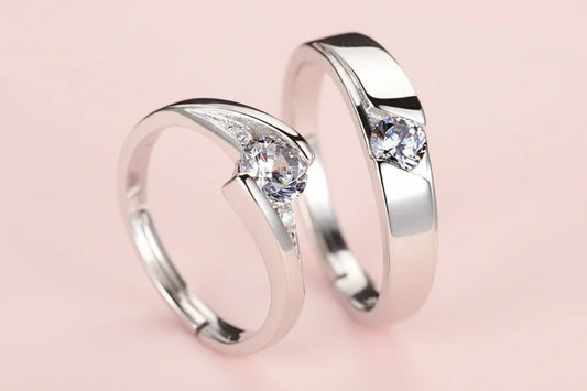 Two silver rings with clear gemstones on a light background
