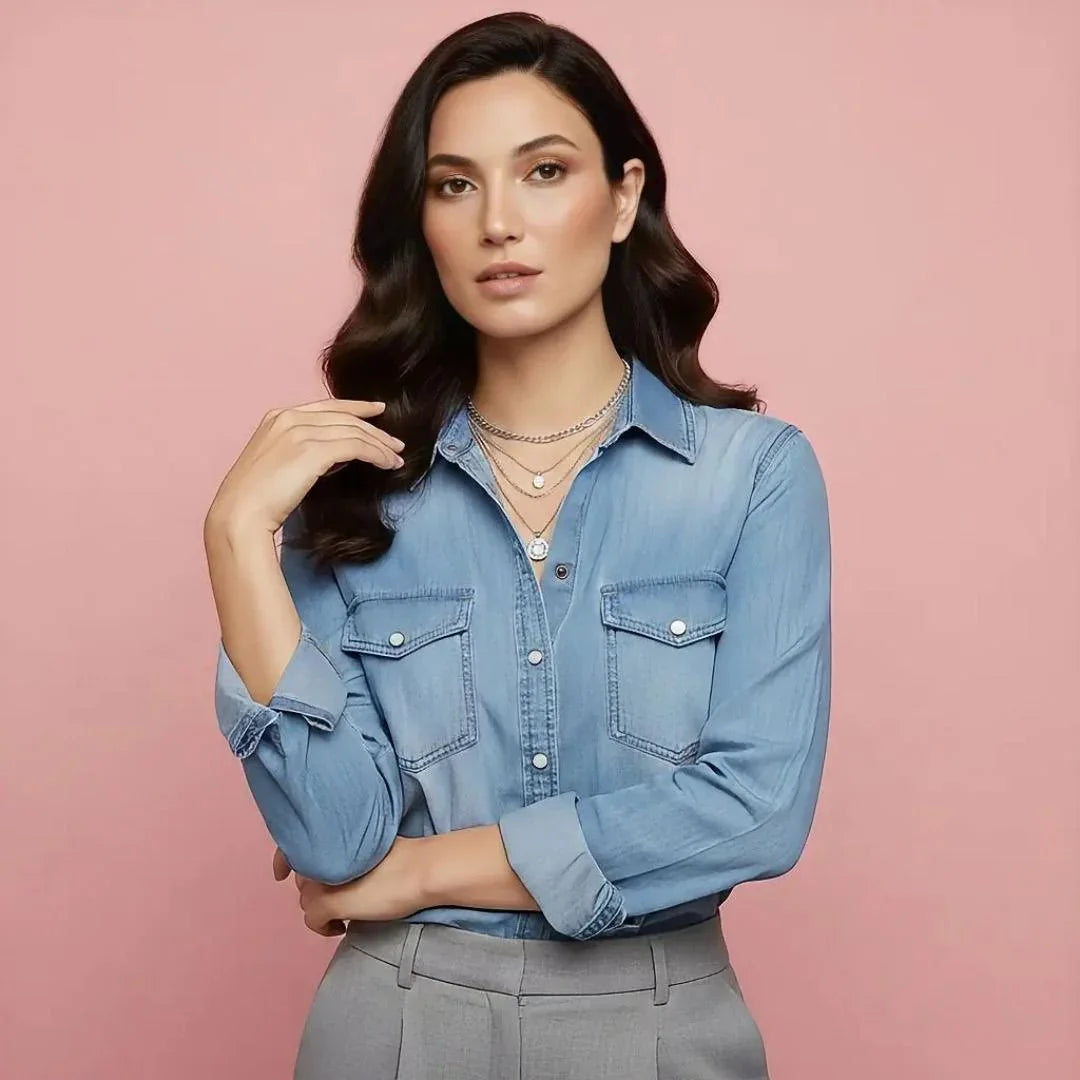Woman wearing a blue denim shirt against a pink background