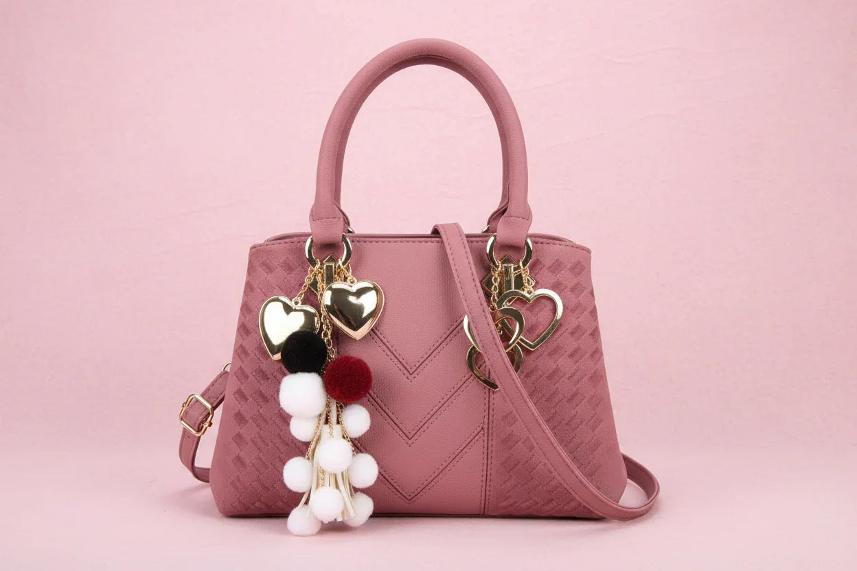 Pink handbag with decorative tassels on a white background