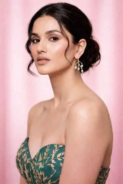 Woman wearing a green strapless dress with floral patterns against a pink background