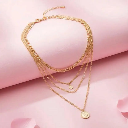 Set of gold necklaces on a pink background