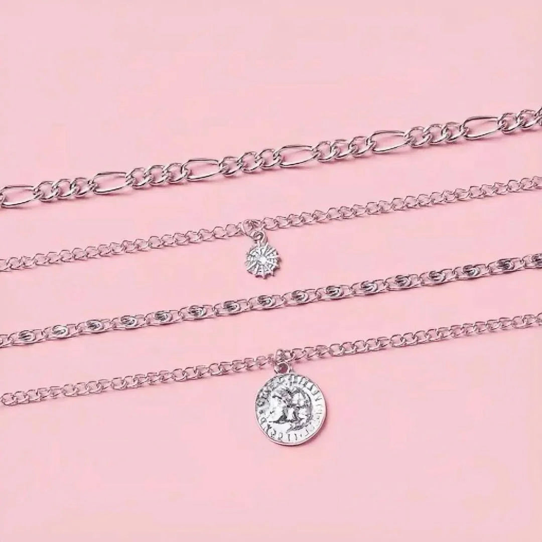 Silver chain necklaces with pendants on a pink background