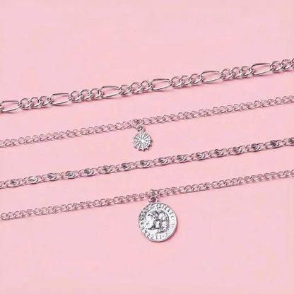 Silver chain necklaces with pendants on a pink background