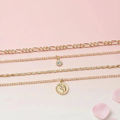 Three gold necklaces with charms on a pink background