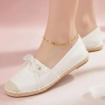 White sneakers with gold accents on a pink background