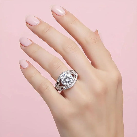Hand wearing a diamond ring on a pink background