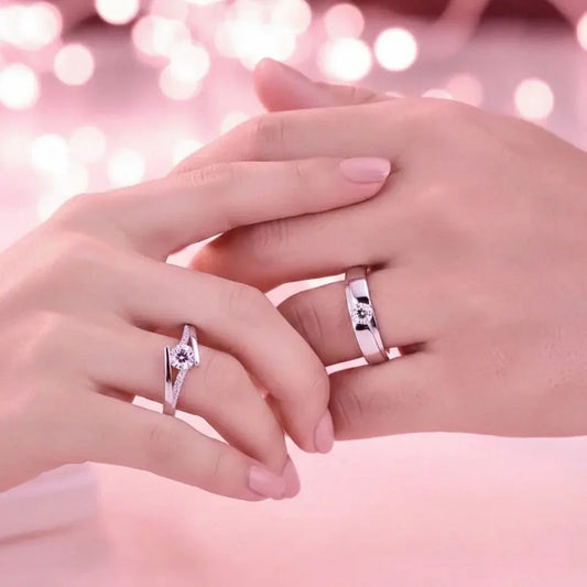 Two hands with rings on a pink blurred background