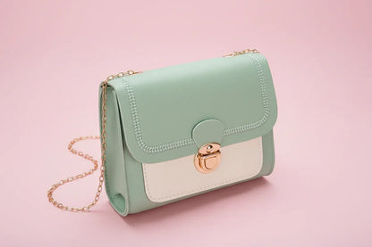 Mint green handbag with gold chain on a white background