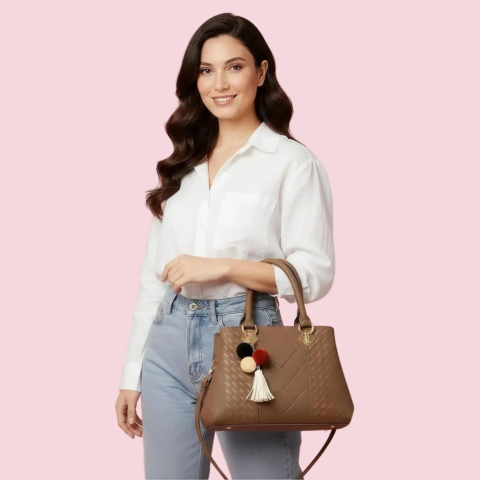 Woman holding a brown handbag with decorative pom-poms against a pink background