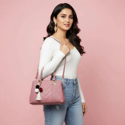Woman holding a pink handbag with pom-poms against a pink background