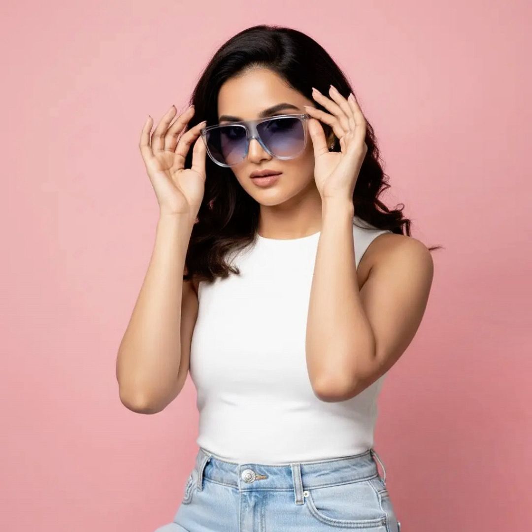 Woman wearing sunglasses and a white top against a pink background
