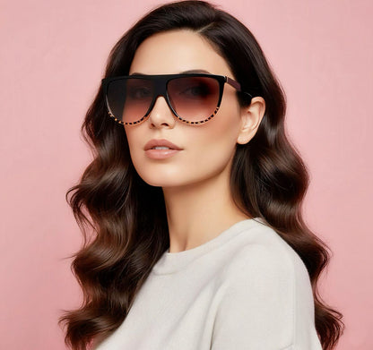 Woman wearing sunglasses with a pink background