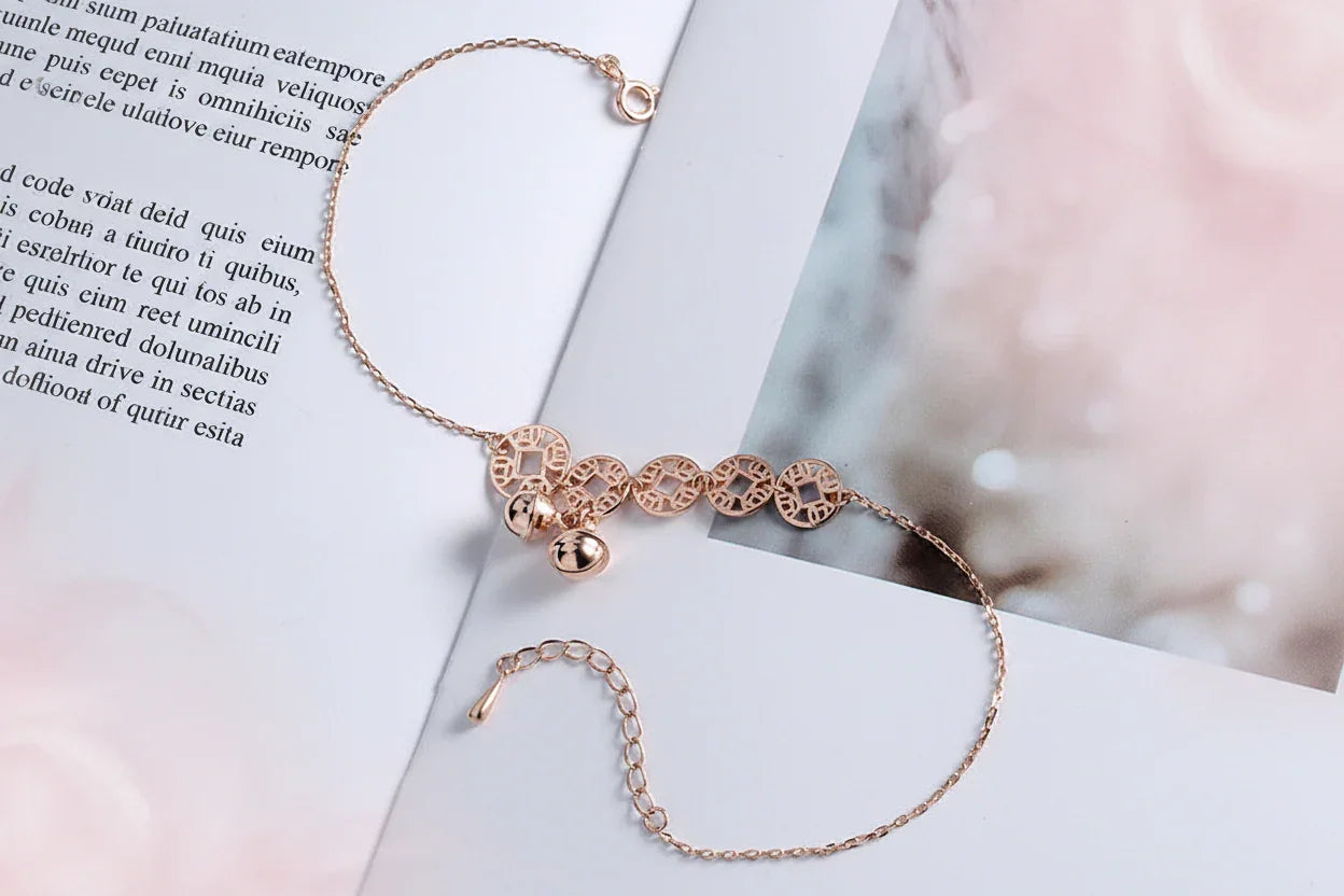 Rose gold bracelet with decorative elements on a white surface
