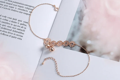 Rose gold bracelet with decorative elements on a white surface
