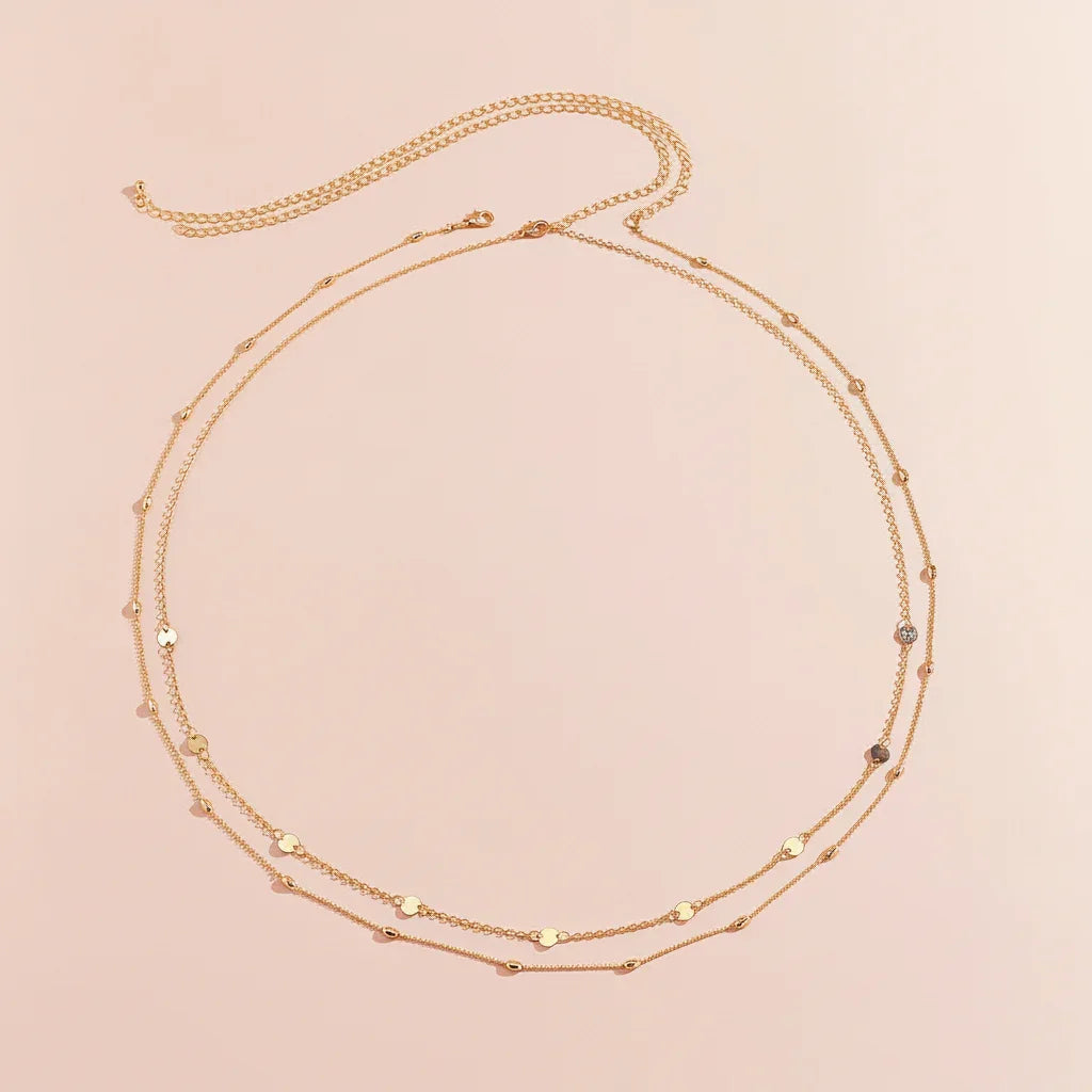 Gold necklace with small beads on a beige background