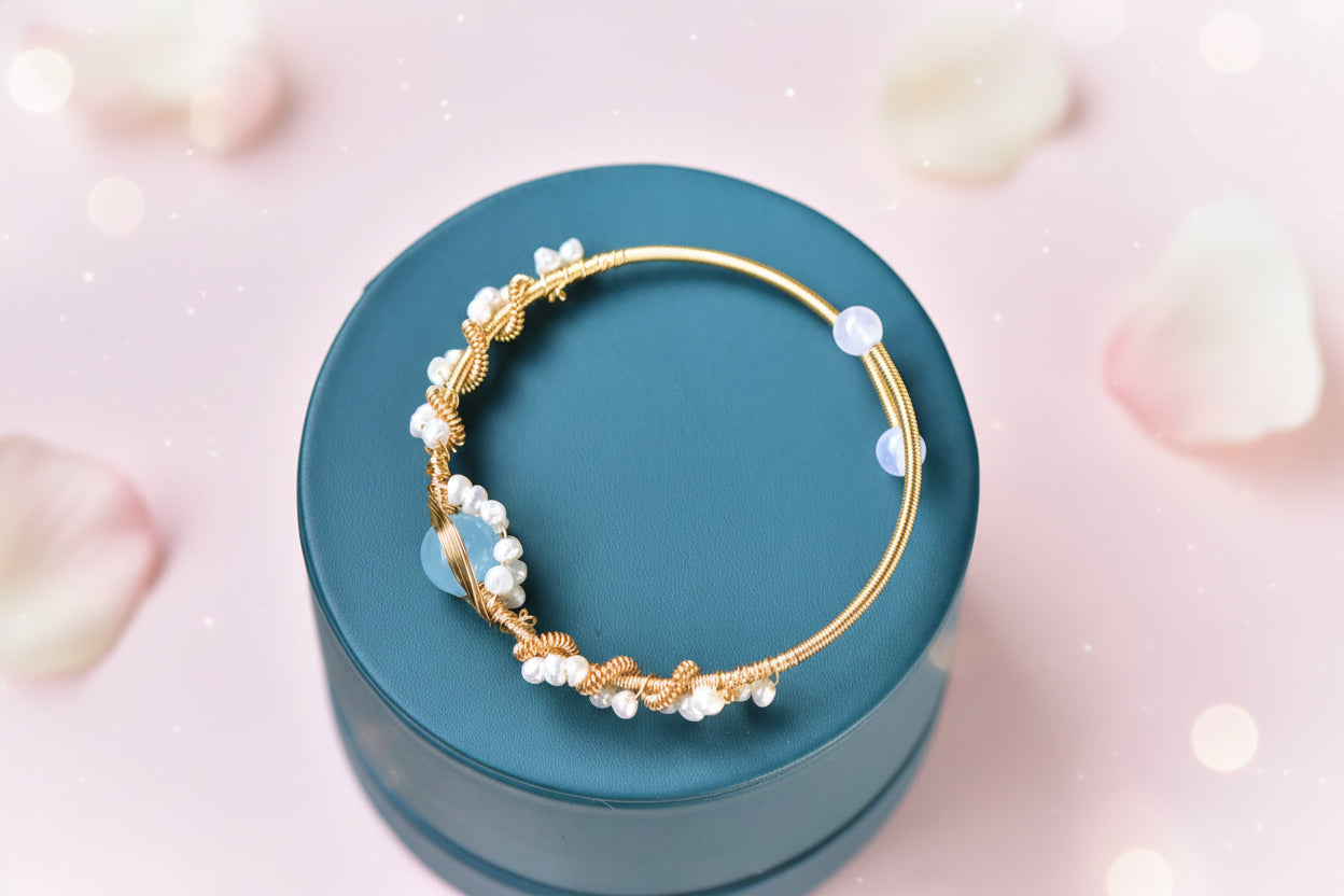 Gold hoop earrings with pearls on a teal jewelry box